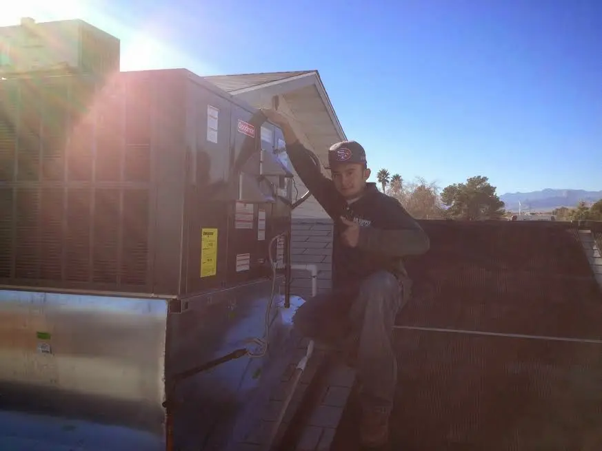 HVAC technician performing AC Tune-Up on a rooftop unit in Cloquet