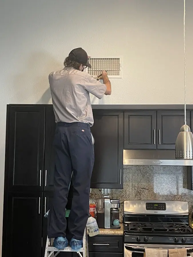 Technician inspecting an air vent during HVAC service in Cloquet